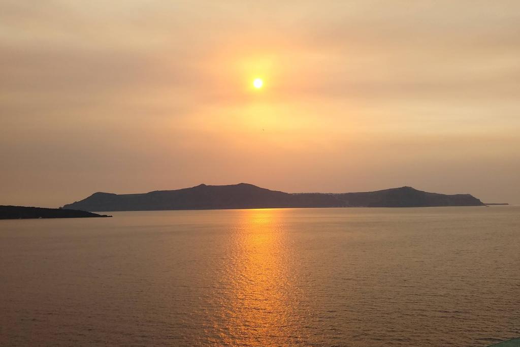 Sunset over Santorini as we sail away completes the day